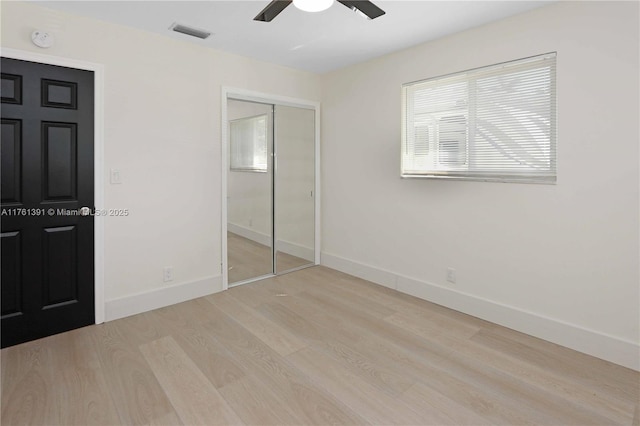 unfurnished bedroom with visible vents, baseboards, a closet, and wood finished floors