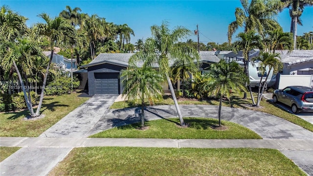 view of front of property featuring a front yard, a garage, and driveway