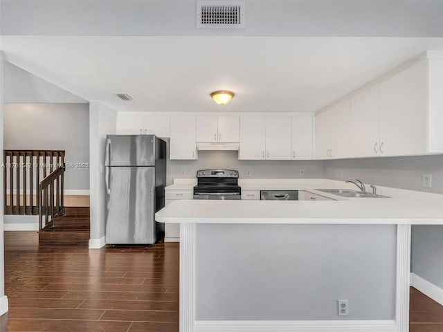 kitchen featuring visible vents, under cabinet range hood, light countertops, stainless steel appliances, and a sink