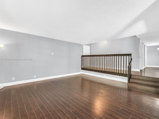 bonus room with wood finished floors, baseboards, and a textured ceiling