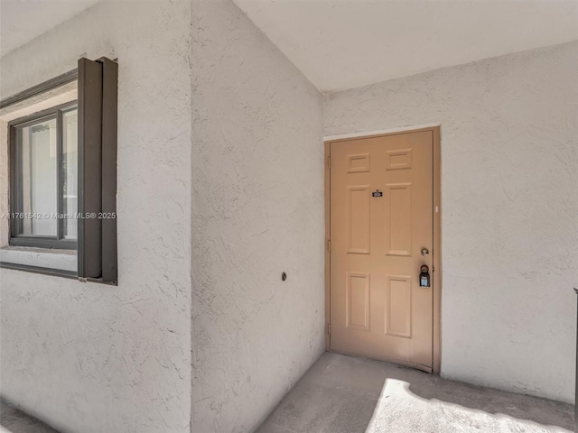 doorway to property featuring stucco siding