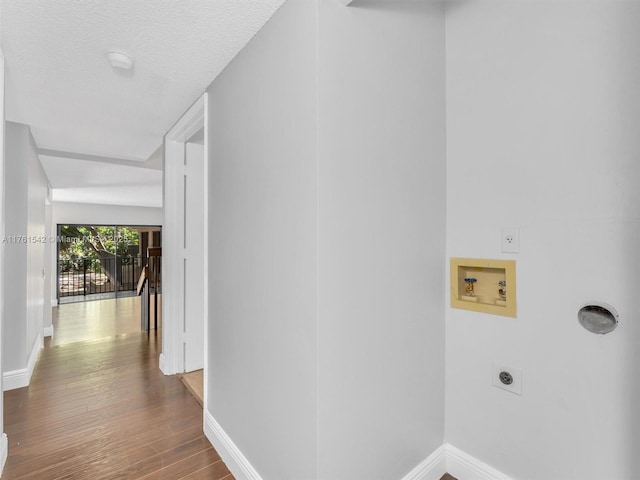 washroom featuring washer hookup, wood finished floors, baseboards, hookup for an electric dryer, and laundry area