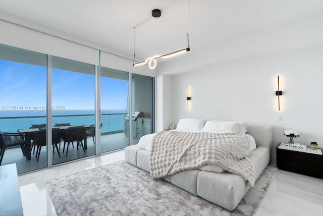 bedroom featuring floor to ceiling windows, a water view, and a closet