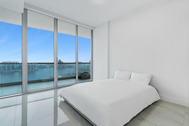 bedroom featuring a wall of windows and baseboards