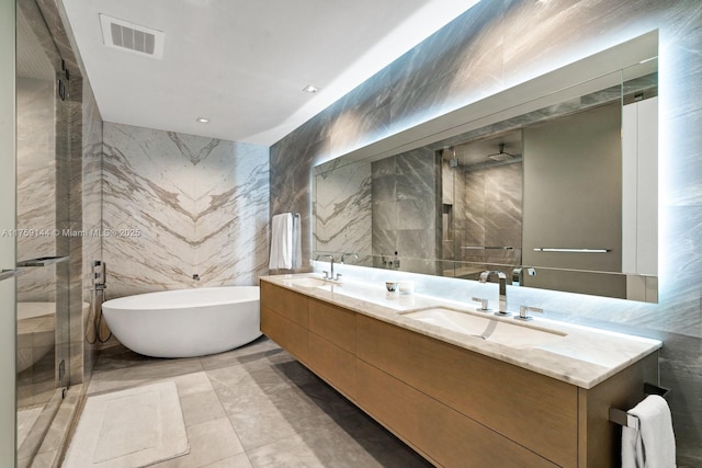 bathroom featuring a sink, visible vents, tile walls, and double vanity