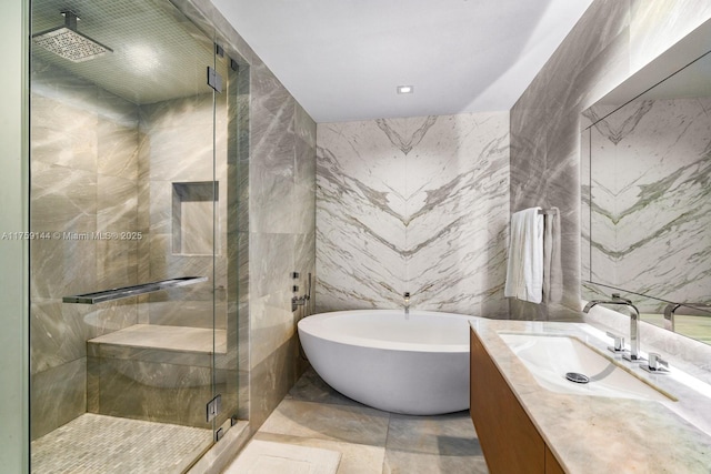 bathroom featuring a freestanding tub, vanity, tile walls, and a shower stall