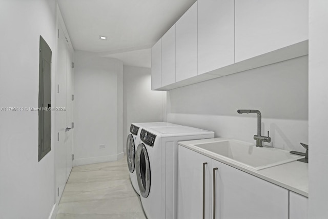 washroom with cabinet space, independent washer and dryer, baseboards, and a sink