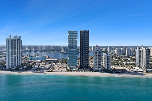 exterior space with a water view, a view of city, and a beach view