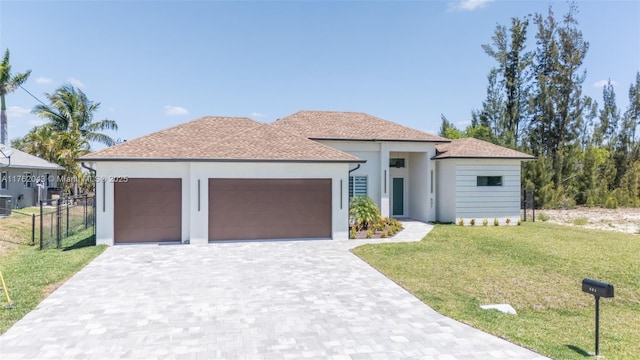 601SW 13th St, Cape Coral, FL 33991 - view of front of house featuring a garage, stucco siding, decorative driveway, and cooling unit
