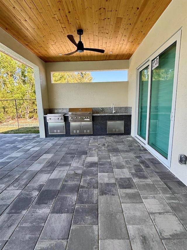 view of patio with area for grilling, ceiling fan, and fence