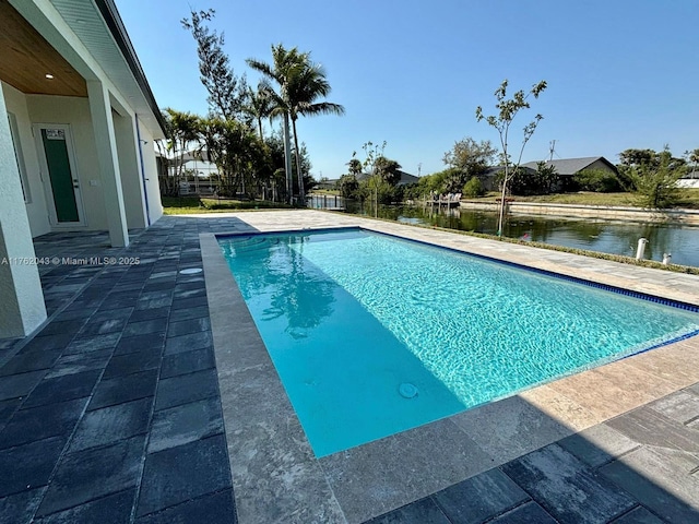 pool featuring a water view and a patio area