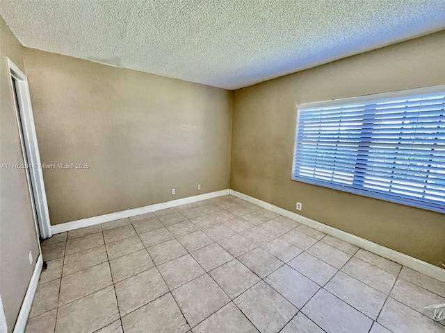 empty room featuring baseboards and a textured ceiling