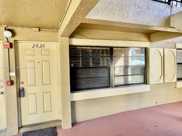 entrance to property featuring stucco siding