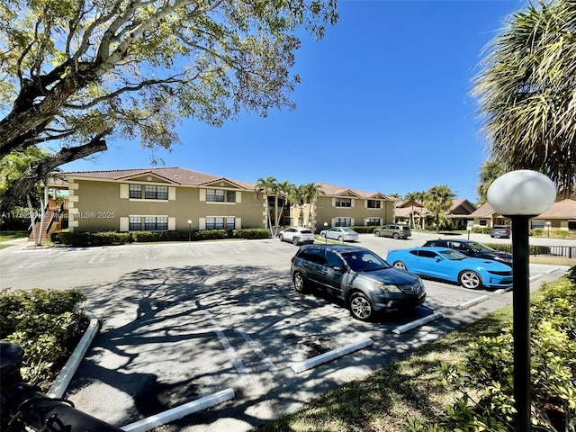 exterior space featuring stucco siding, a residential view, and uncovered parking