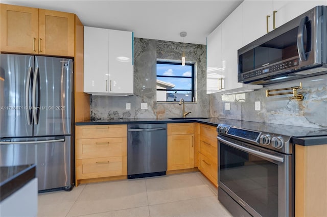 kitchen with dark countertops, backsplash, light tile patterned flooring, stainless steel appliances, and a sink