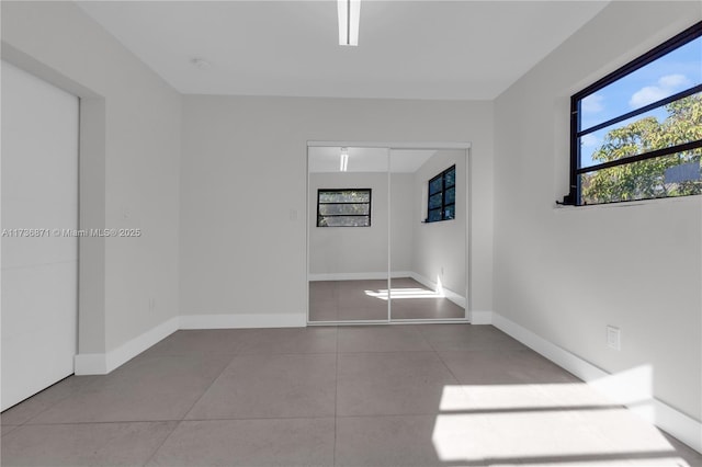 empty room featuring tile patterned flooring and baseboards