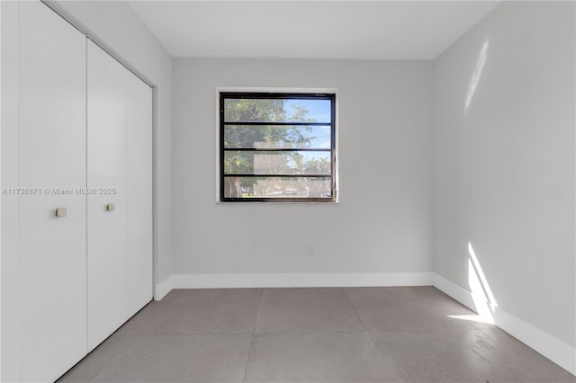 unfurnished bedroom with a closet and baseboards