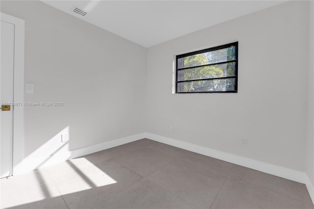 unfurnished room featuring baseboards and visible vents