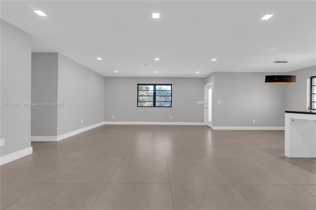 unfurnished living room featuring recessed lighting, baseboards, and light tile patterned floors