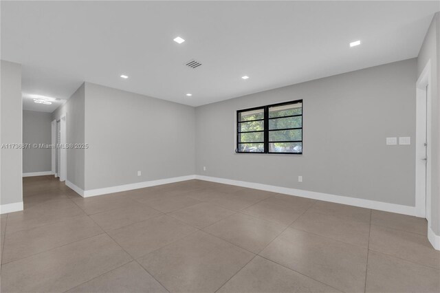 empty room with recessed lighting, visible vents, and baseboards