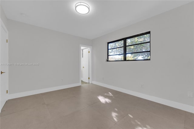 unfurnished room featuring baseboards