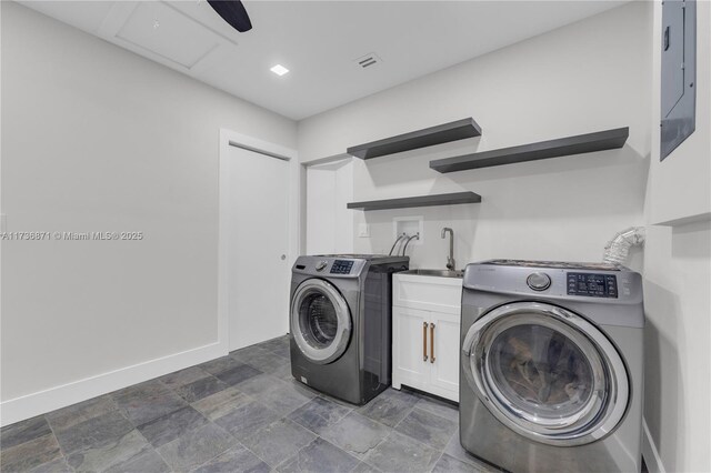 washroom with a sink, baseboards, cabinet space, and washer / dryer