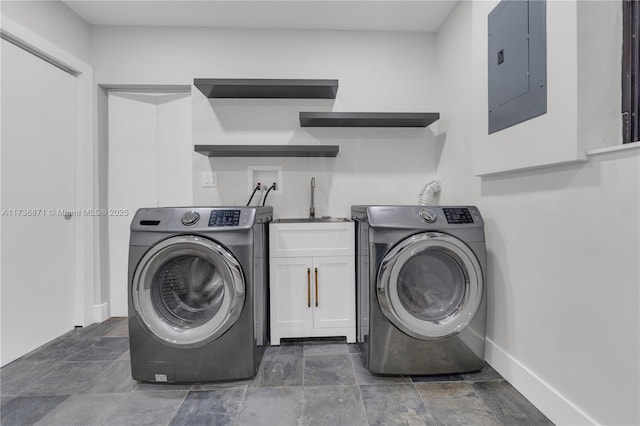 clothes washing area with electric panel, cabinet space, washer / dryer, and a sink