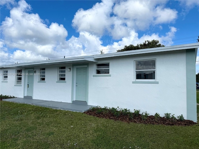 ranch-style house with stucco siding and a front lawn