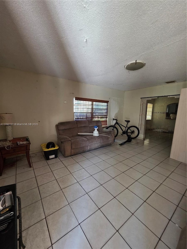 living room with light tile patterned floors, visible vents, and a textured ceiling