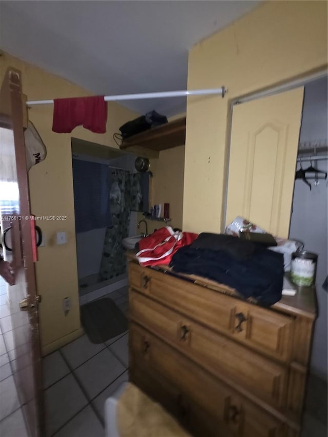 bedroom with light tile patterned floors and a sink