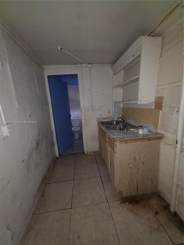 kitchen featuring light tile patterned flooring and a sink