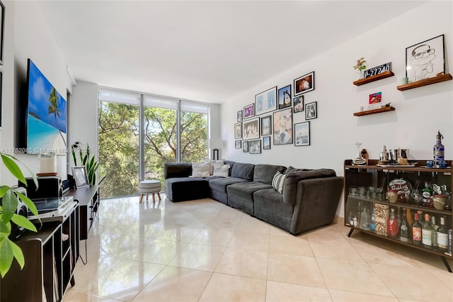 living room with a wall of windows and light tile patterned flooring