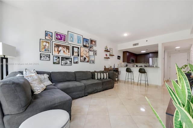 living room featuring visible vents and light tile patterned flooring