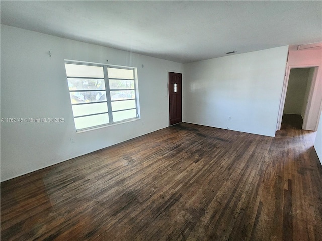 unfurnished living room with dark wood finished floors and visible vents