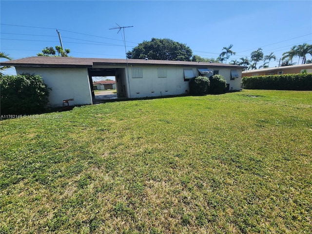 back of house with an attached carport and a yard