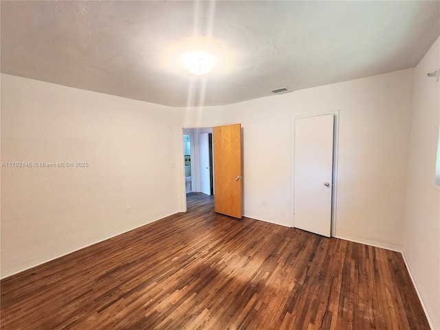 unfurnished bedroom with visible vents and wood finished floors