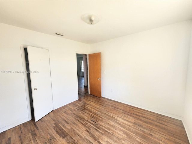 empty room with visible vents, baseboards, and wood finished floors