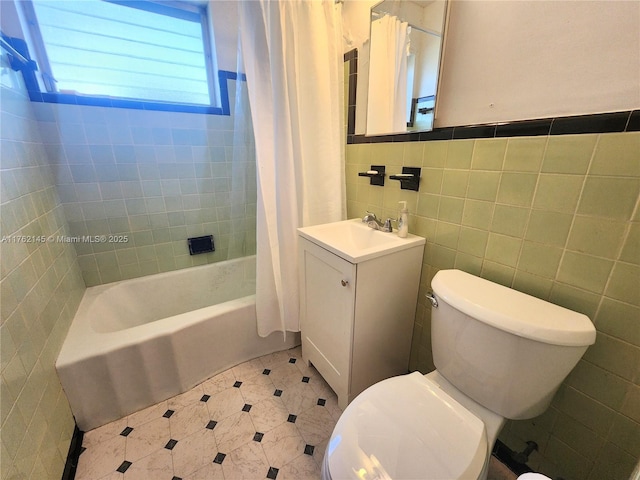 full bath featuring shower / bath combo with shower curtain, toilet, tile walls, and vanity