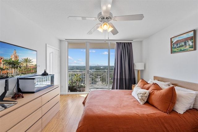 bedroom with access to exterior, floor to ceiling windows, light wood-style flooring, and a ceiling fan