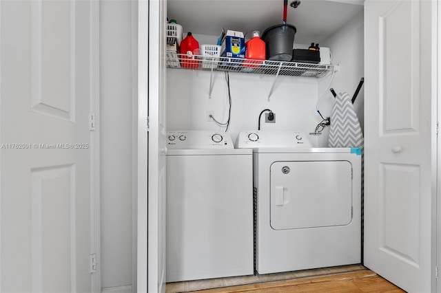 laundry room with laundry area, light wood finished floors, and washing machine and clothes dryer