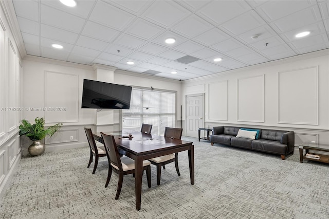 dining space featuring a decorative wall, recessed lighting, light colored carpet, and ornamental molding