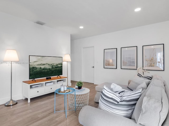 living room with recessed lighting, visible vents, baseboards, and light wood finished floors