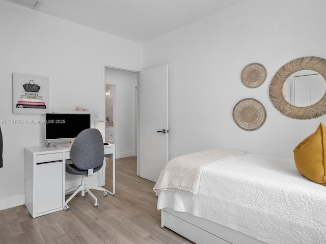 bedroom with light wood-type flooring and baseboards