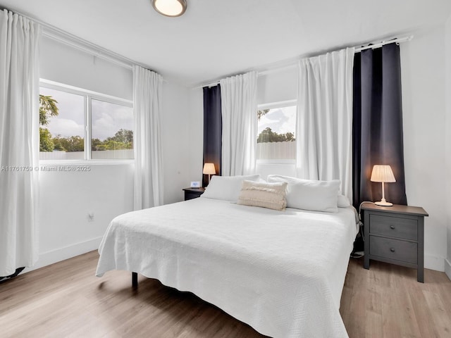 bedroom with baseboards and light wood finished floors