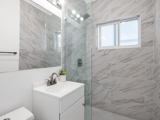 bathroom featuring toilet, vanity, and a walk in shower