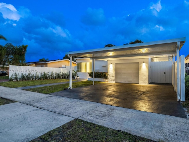 view of front of house featuring concrete driveway, fence, a garage, and a front yard