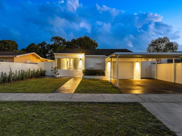 view of front of house featuring concrete driveway, fence, a front lawn, and stucco siding