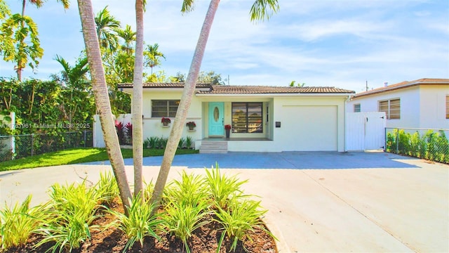 view of front of house featuring fence, an attached garage, stucco siding, concrete driveway, and a tile roof