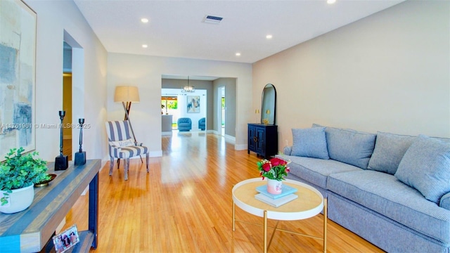 living area with visible vents, recessed lighting, light wood-type flooring, and baseboards