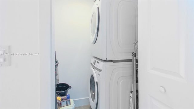 clothes washing area featuring stacked washer / drying machine and laundry area